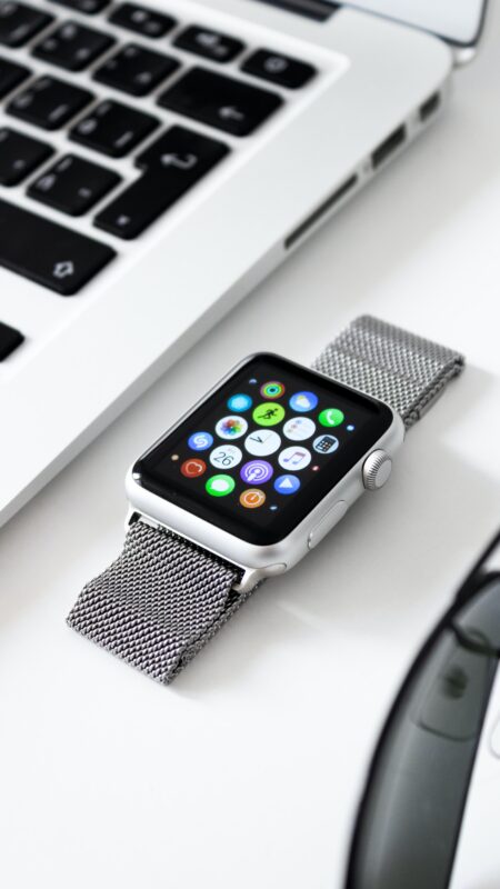 Apple watch close to MacBook on a white table