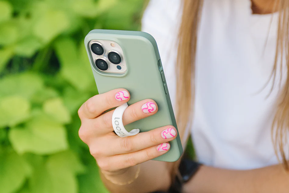 A woman holding a phone in a loopy case.