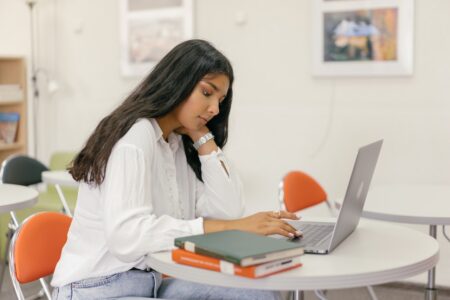 Best Laptops for College Students: A female college student in classroom with studying with her laptop