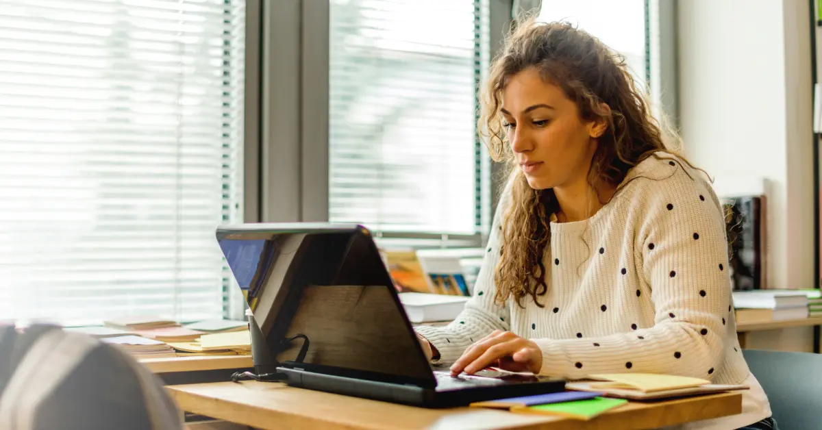 A young lady taking online classes with a laptop